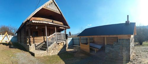 a small log cabin with a black roof at "Бджілка" і " Садиба для відпочинку" in Lyuta