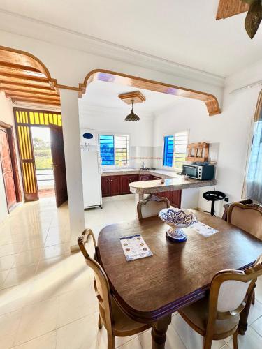 a kitchen and dining room with a wooden table and chairs at Duplex Oualidia surfhouse in Oualidia
