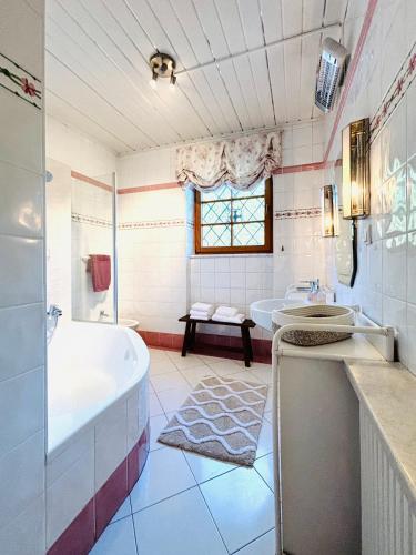a bathroom with a tub and two sinks and a bath tub at Hideaway Sandlehen in Sonntagberg