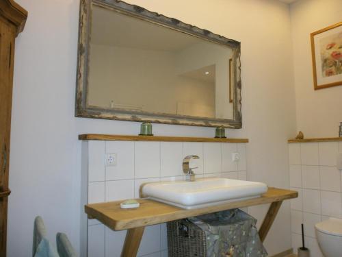 a bathroom with a sink and a mirror at Ferienhaus Zum Roten Gaul in Heidmühlen