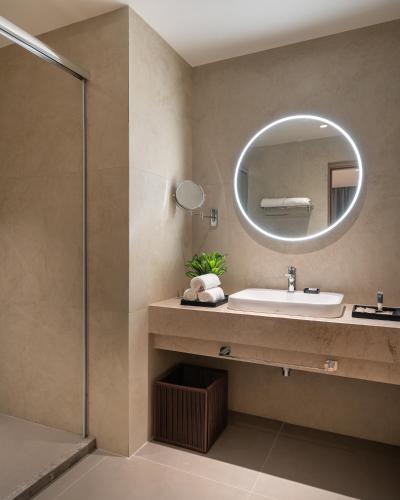 a bathroom with a sink and a mirror at Copper Leaf Hotels, Tirunelveli in Tirunelveli