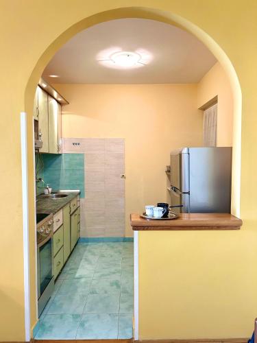 a kitchen with an archway with a refrigerator in it at Big Apartment with Wifi, AC and SmartTV in Novi Sad