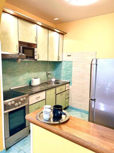 a kitchen with a refrigerator and a wooden counter top at Big Apartment with Wifi, AC and SmartTV in Novi Sad