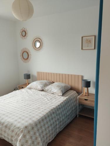 a bedroom with a bed with two lamps and two mirrors at Maison Centre bourg in Nort-sur-Erdre
