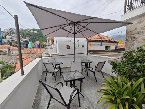 a patio with tables and chairs and an umbrella at Beatrix Suites in Budva