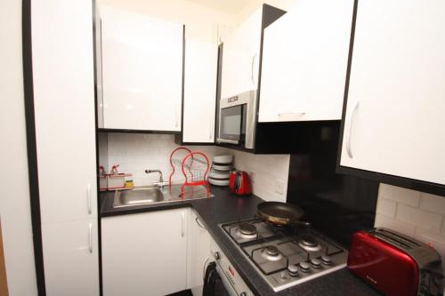 a small kitchen with a stove and a sink at Raeburn in Aberdeen