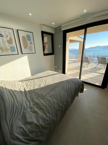 une chambre avec un lit et une vue sur l'océan dans l'établissement La Renarde, au Lavandou