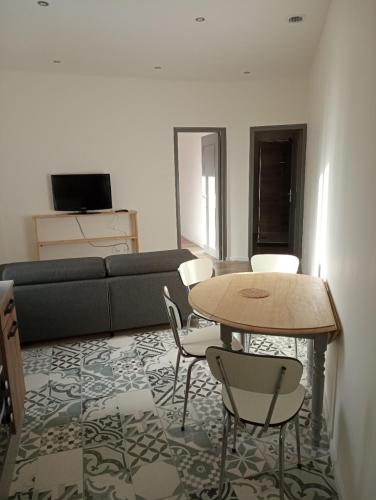 a living room with a couch and a table and chairs at Appart proche toutes commodités in Souvigny