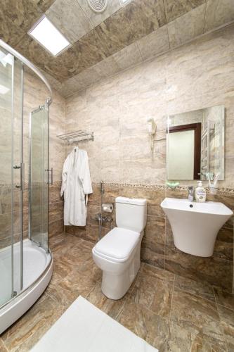 a bathroom with a toilet and a sink and a shower at Amea Baku Hotel in Baku