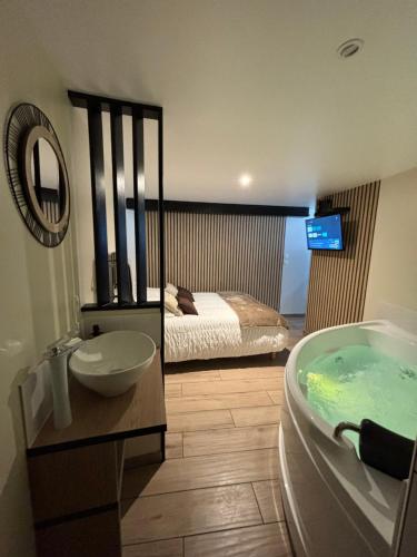 a bathroom with a tub and a bedroom with a bed at Tiny room in Langres