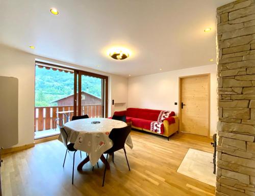 a living room with a table and a red couch at Magnifique 3 Pièces 60m2 central et proximité du lac in Bozel