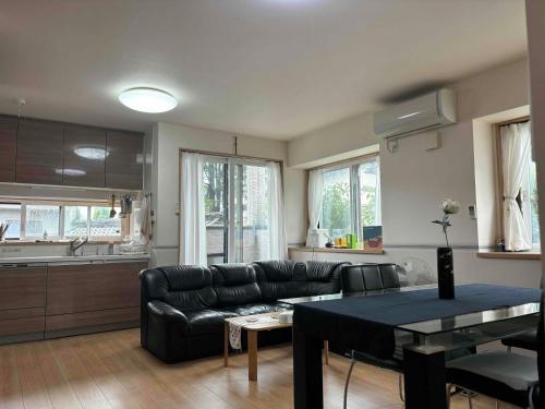 a living room with a couch and a table at Guest House Harukawa in Osaka