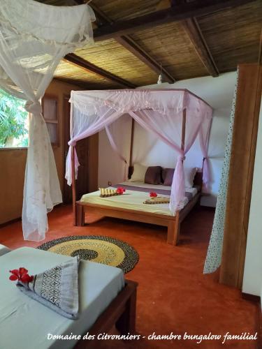 a bedroom with a bed with a canopy at Les Citronniers in Sainte Marie