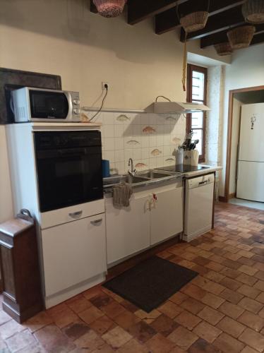 a kitchen with a stove and a microwave at Pêches de Vignes in Fouquebrune