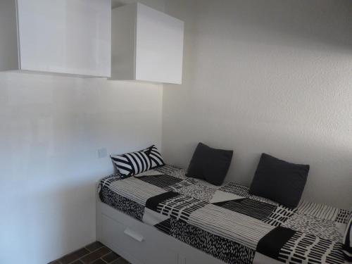 - une chambre avec 2 lits et des oreillers noirs et blancs dans l'établissement Studio port Hyères 200m mer parking privé, à Hyères