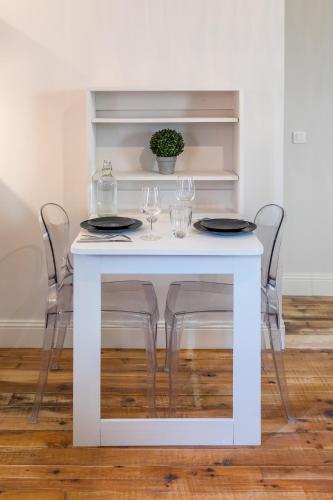 - une table blanche avec deux chaises et des verres dans l'établissement Les deux clefs acte 2, à Mont-de-Marsan