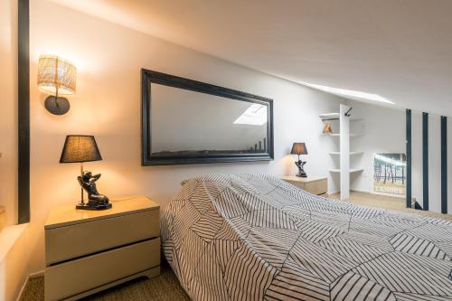 a bedroom with a bed and a large mirror at Les deux clefs acte 2 in Mont-de-Marsan