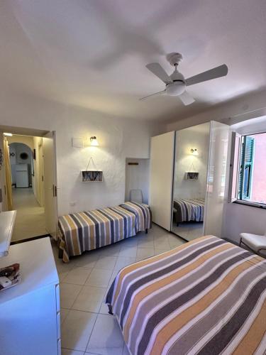 a bedroom with two beds and a ceiling fan at La casa di Andreina in Monterosso al Mare