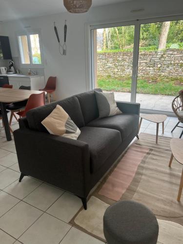 un salon avec un canapé noir et une table dans l'établissement Les Flamants roses, à Châteaubriant