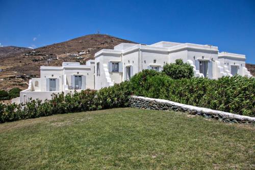 a white house with a hill in the background at Iris house Agios Sostis in Agios Sostis