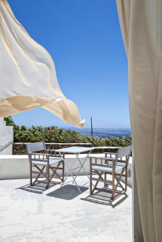 a patio with a table and chairs and the ocean at Iris house Agios Sostis in Agios Sostis