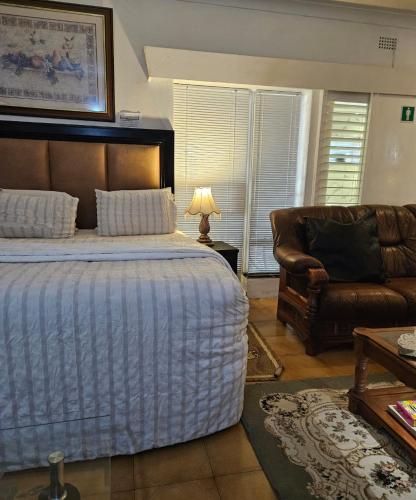 a bedroom with a bed and a couch at The Royal Princess B&B on Malibongwe Drive in Johannesburg