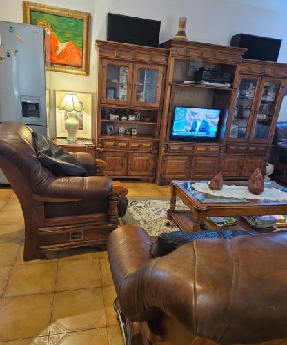 a living room with leather furniture and a tv at The Royal Princess B&B on Malibongwe Drive in Johannesburg