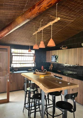 une cuisine avec une grande table et des chaises en bois dans l'établissement Villa LILY BAY baie de Santa Giulia-Porto Vecchio, à Porto-Vecchio