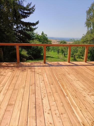 a wooden deck with a fence and trees at Vacation Home Pani haje in Moravany