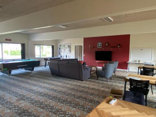 a living room with couches and a pool table at Tvind B&B in Ulfborg