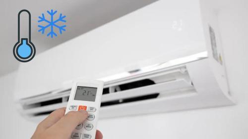 a person holding a remote control in front of an air conditioner at ONNEA - Magical Chalet with Stunning Views, Sauna & Hot Tub in Petite-Rivière-Saint-François