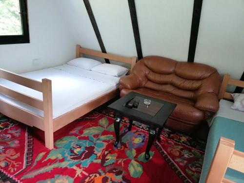 a bedroom with a bed and a chair and a table at Koliba TAMAN in Konjic