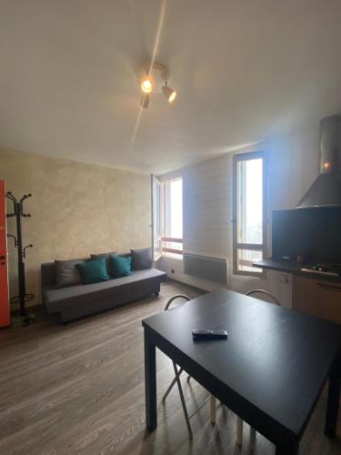 a living room with a couch and a table at Appartement Le SKICOSY à Guzet Neige in Ustou