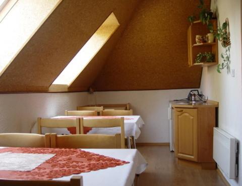 a dining room with tables and chairs and a skylight at Pension Nostalgie in Beroun