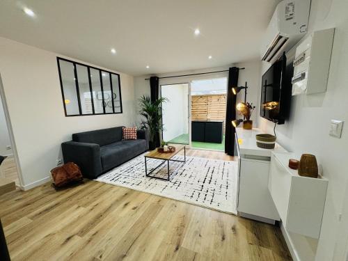 un salon avec un canapé et une table dans l'établissement Le Bel Air - Terrasse - WIFI, à Bègles