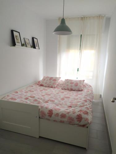 a bed in a white room with a window at Vistahermosa-El ancla in El Puerto de Santa María