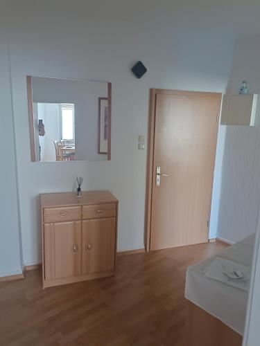an empty room with a door and a wooden cabinet at Nette Kuschelige Terrassen Wohnung in Bochum