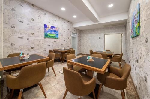 a restaurant with tables and chairs in a room at Amea Baku Hotel in Baku