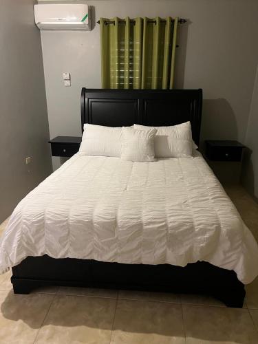 a large bed with a white comforter and pillows at Reddie Vacation Homes in Windsor