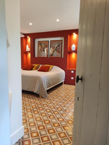 - une chambre avec un lit dans un mur rouge dans l'établissement L'étoffe, charmante chambre dans un Mas Cévenol, à Boisset-et-Gaujac