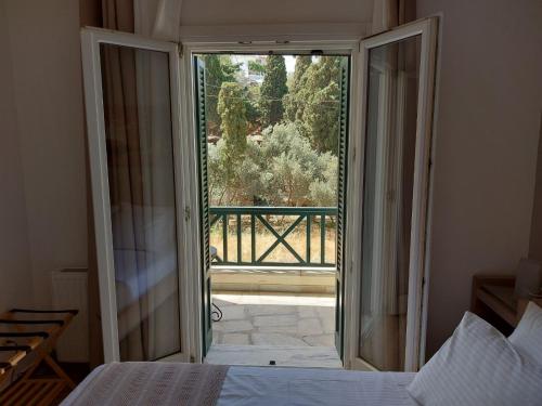 a bedroom with a door open to a balcony at Mpatsi Sunset House in Batsi
