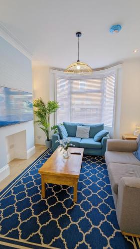 a living room with a blue couch and a coffee table at Sea Breeze House in Scarborough