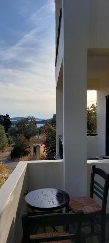 a table and a bench on a balcony with a view at Mpatsi Sunset House in Batsi