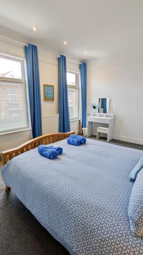a bedroom with a bed with blue pillows on it at Sea Breeze House in Scarborough