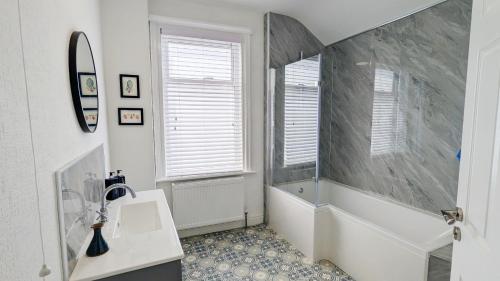 a bathroom with a shower and a sink and a window at Sea Breeze House in Scarborough