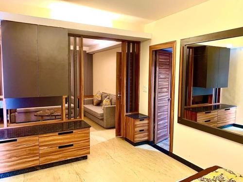 a living room with a large kitchen with wooden cabinets at Le Magnifique in Porvorim