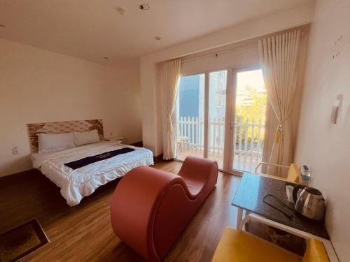 Un dormitorio con una cama y una ventana con balcón. en Nice Hotel Buôn Ma Thuột, en Buon Ma Thuot