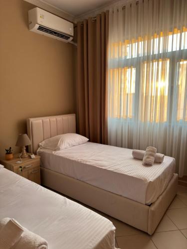 a bedroom with two beds and a window at ErLi Apartment in Shkodër