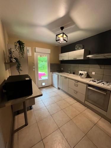 une grande cuisine avec un comptoir et une table. dans l'établissement Au dessus des près, à Lye