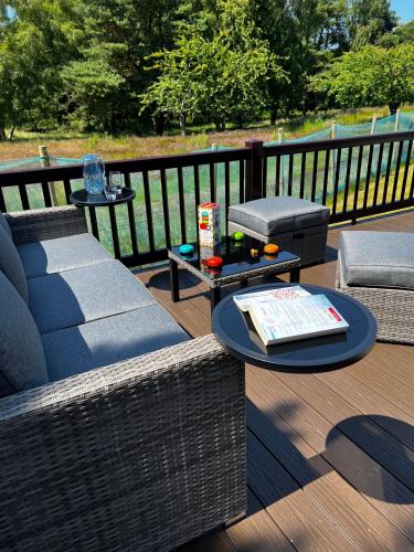 a patio with a couch and a table and chairs at Tranquil Pines in Great Yarmouth